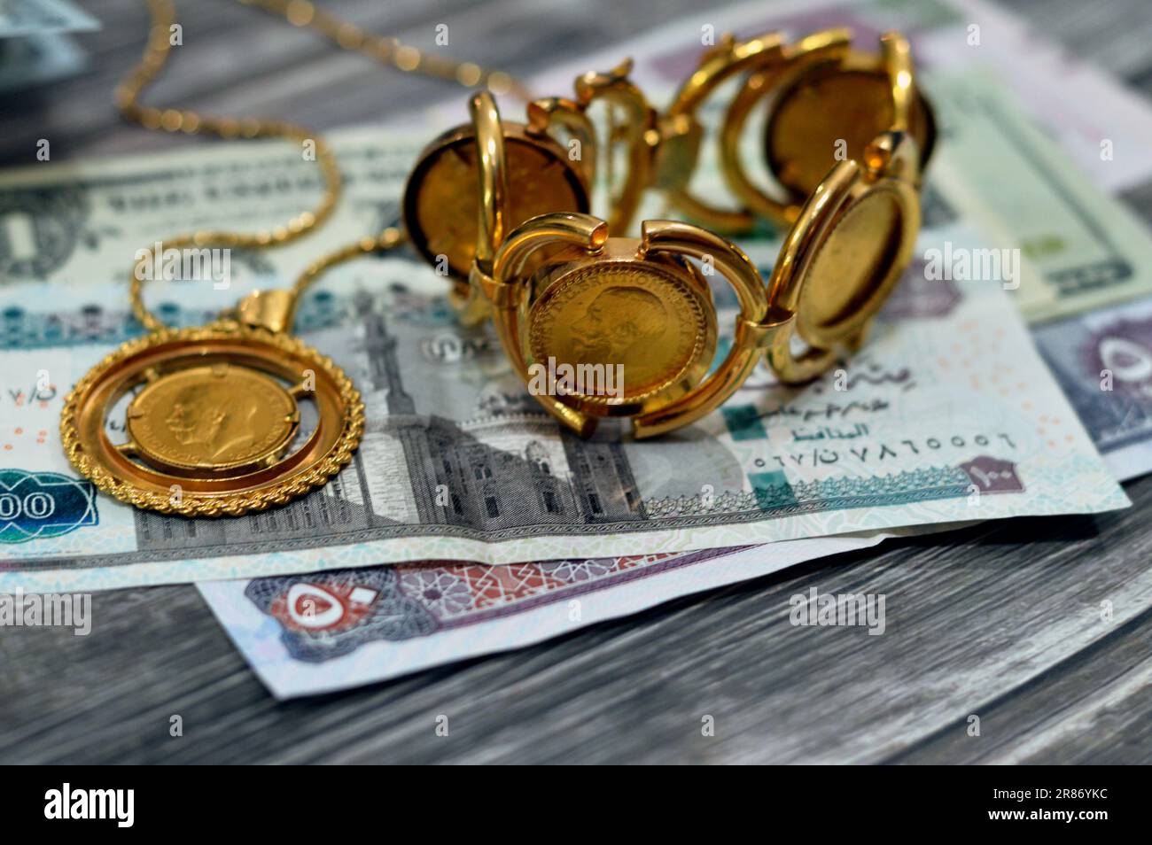 American dollars, Egyptian pounds and Saudi Arabia Riyals banknotes currency bills money with sovereign British gold coins shapes bullion coin feature Stock Photo