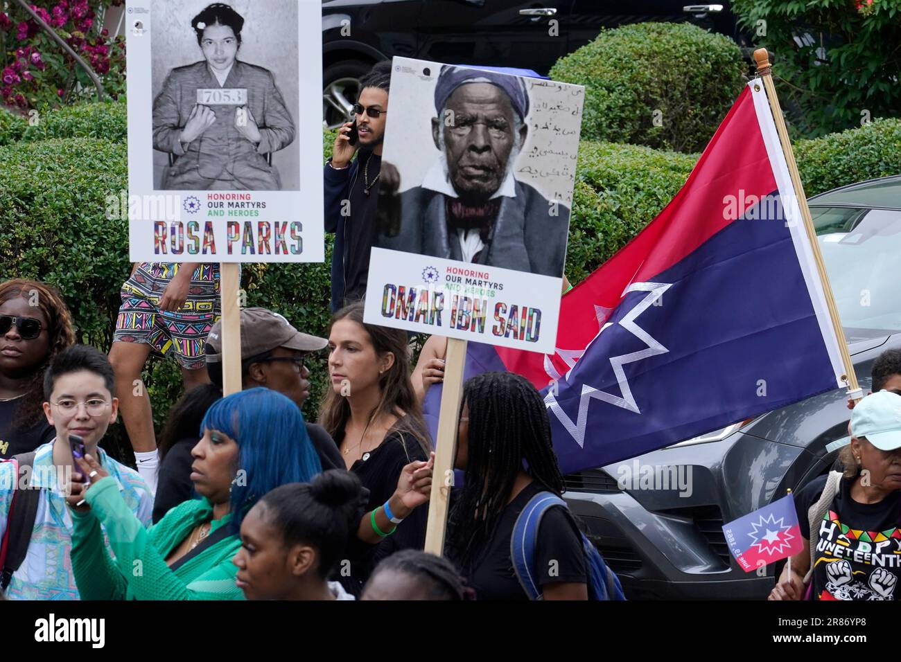People carry posters of civil rights activist Rosa Parks, top left, and ...