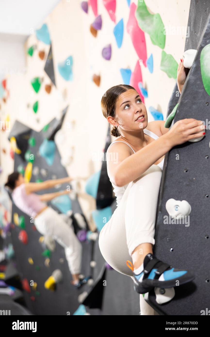 Young Female Alpinist Practicing Indoor A Rock-climbing On A Artificial ...