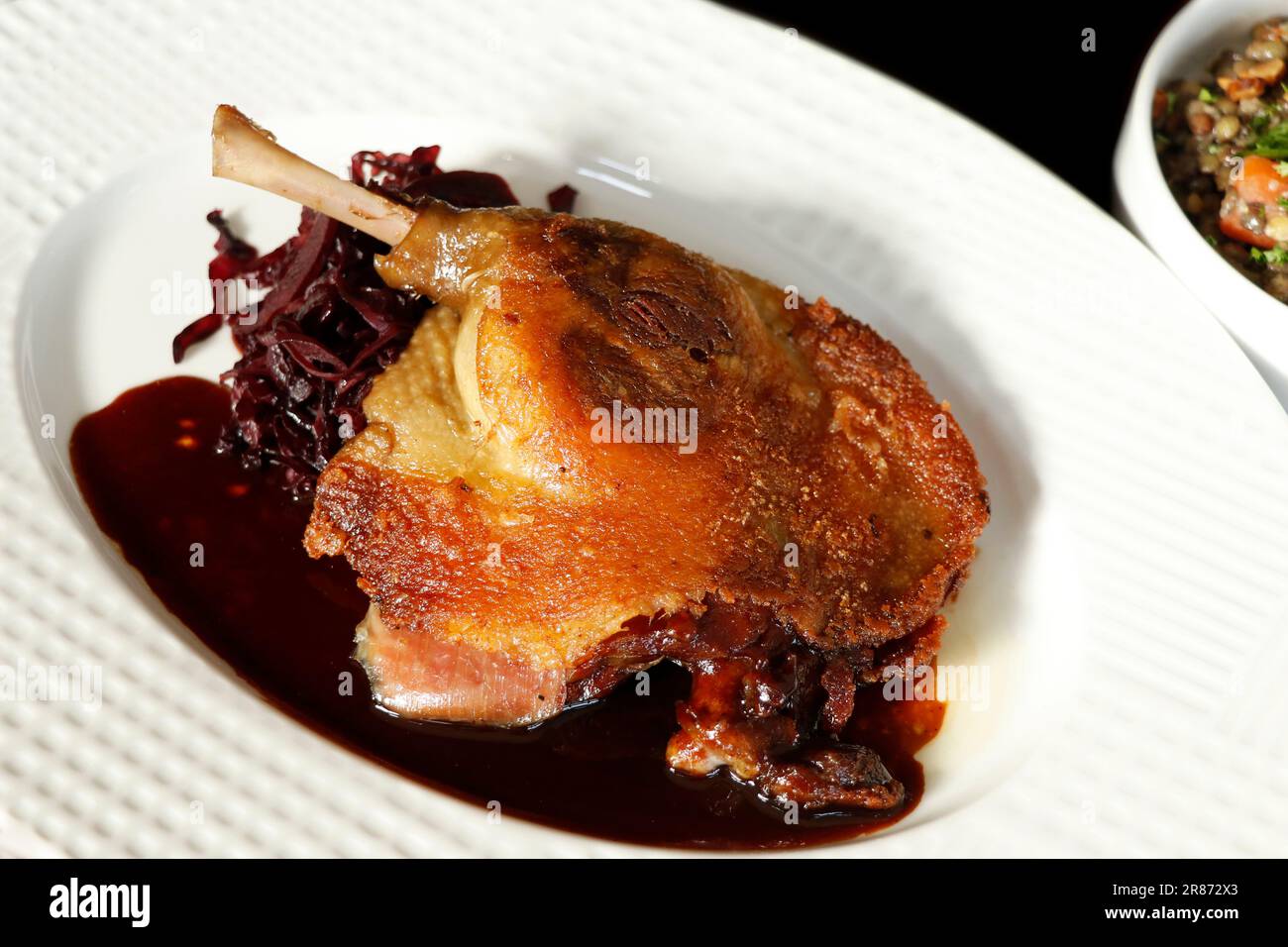 traditional confit french crispy skin on duck leg with braised red
