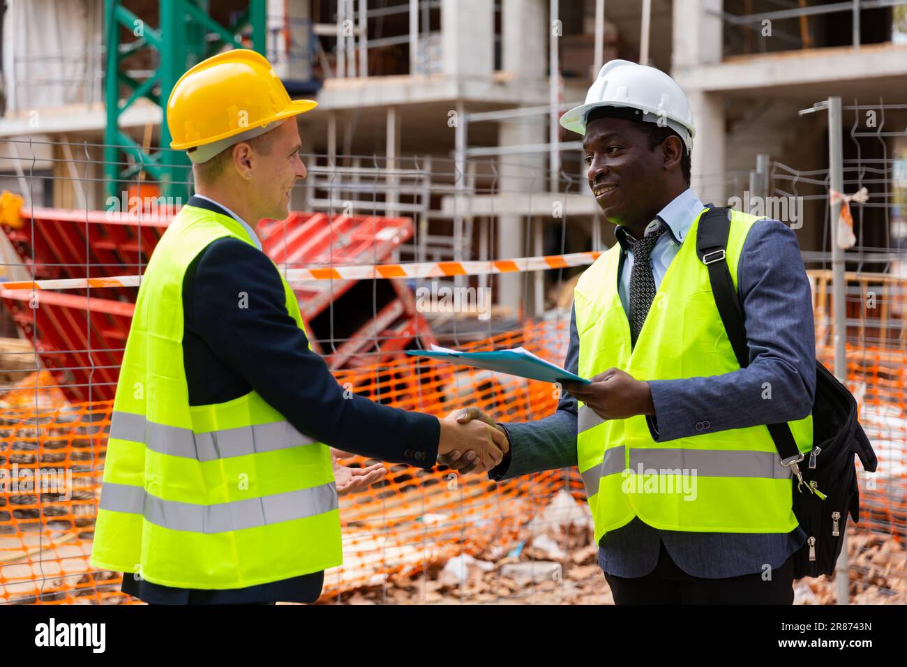 Two engineers concluding agreement and shaking hands Stock Photo