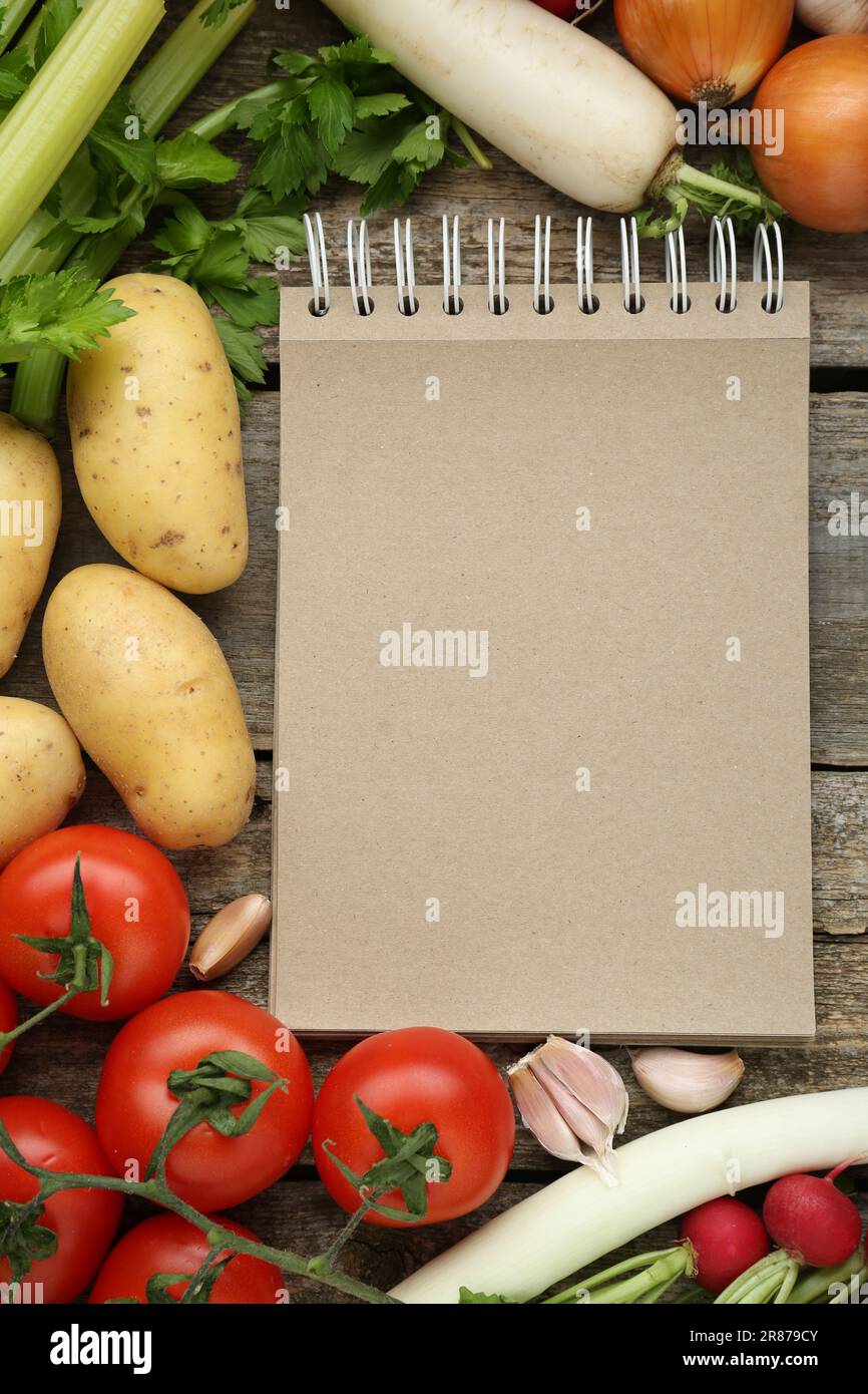Blank recipe book and different ingredients on wooden table, flat lay. Space for text Stock Photo