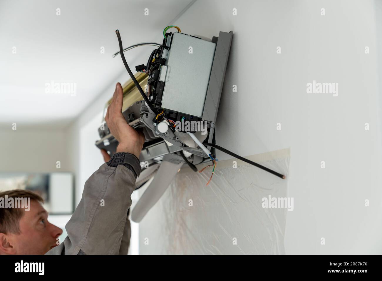 Man technician repairing apartment air conditioner Stock Photo
