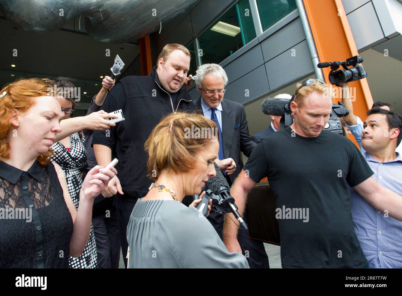 Kim Dotcom (aka Kim Schmitz), centre top, accompanied by lawyer Willy Akel, is released on bail at the District Court  on charges in a US led copyright infringement Investigation, North Shore, Auckland, New Zealand, Wednesday, February 22, 2012. Stock Photo