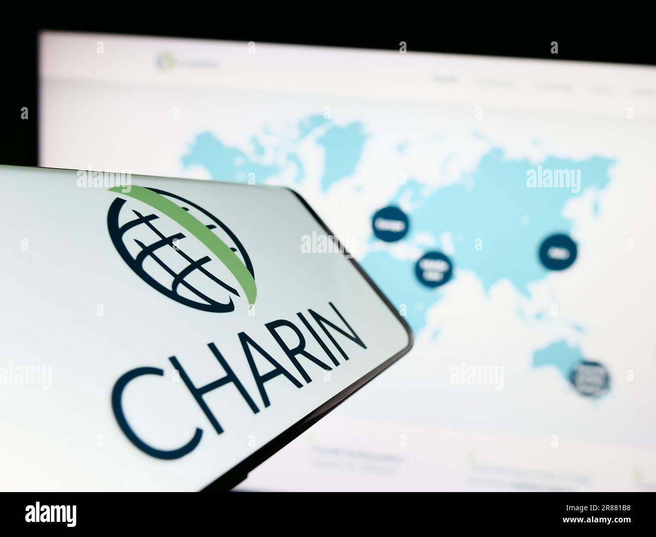Smartphone with logo of global charging association CharIN e.V. on screen in front of website. Focus on center-right of phone display. Stock Photo