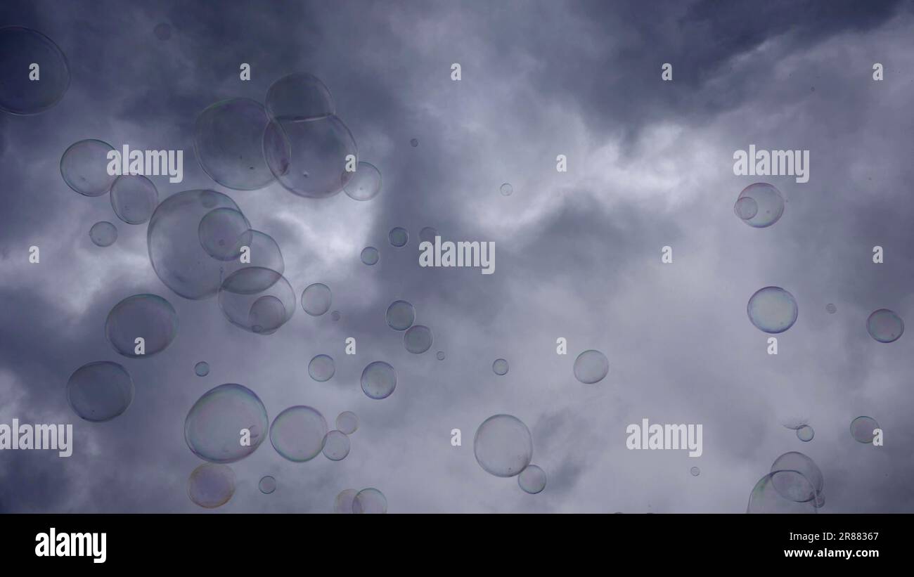 Soap bubbles are flying on gray cloudy sky background Stock Photo - Alamy, image size:1300x821