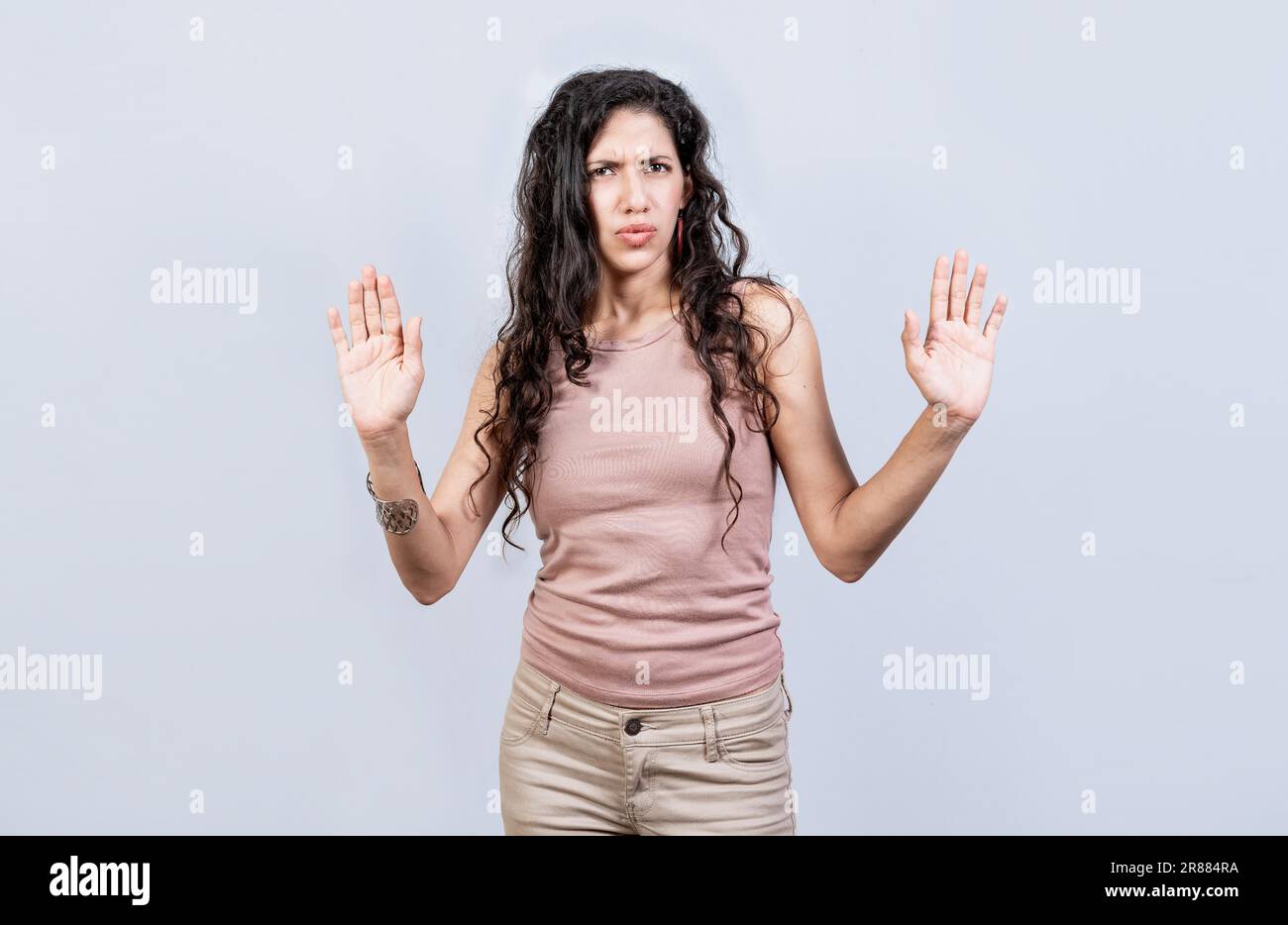 Scared woman with raised hands isolated. Young woman with scared face with raised hands, Scared and horrified girl with raised palms Stock Photo