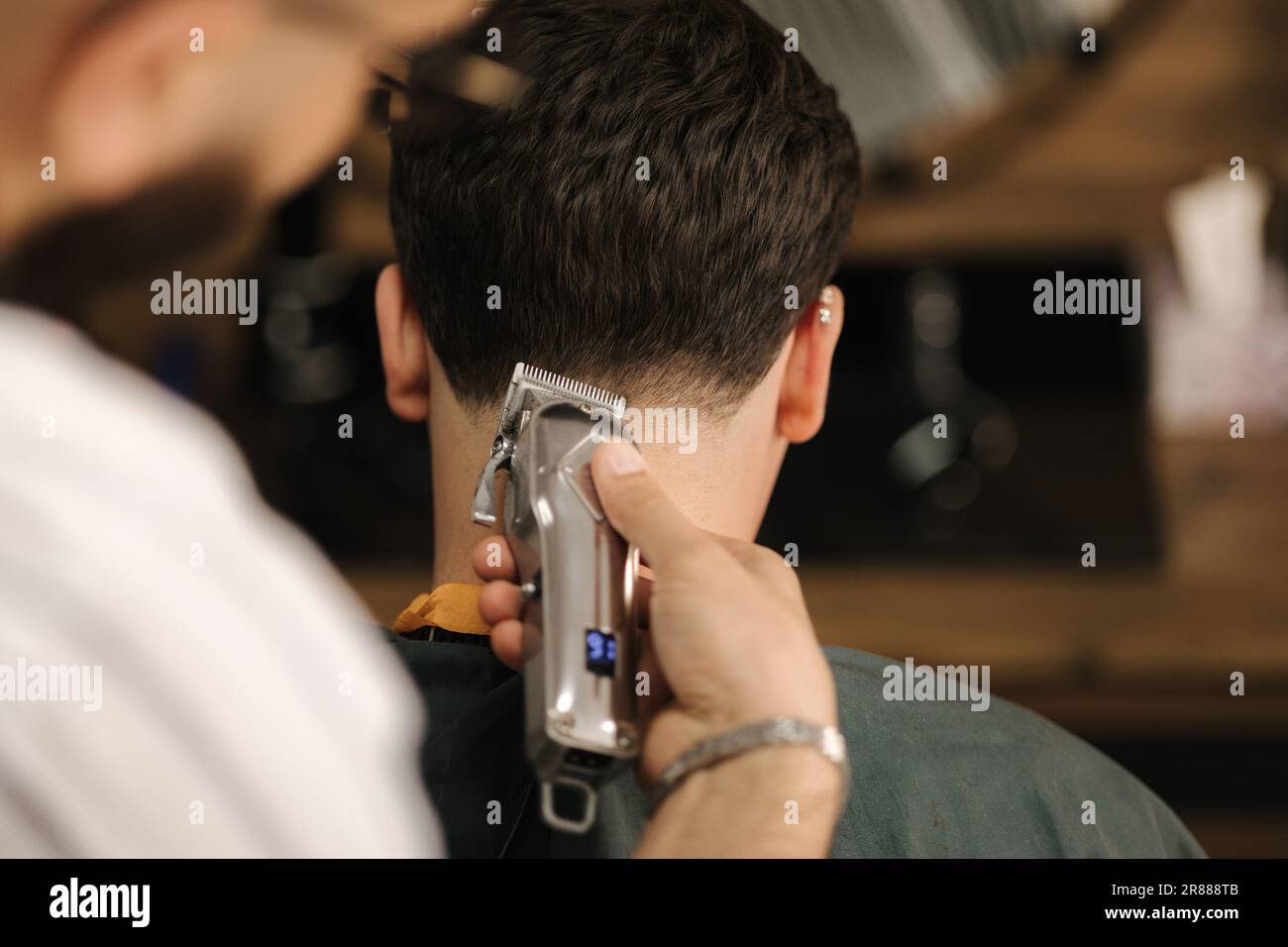 Barber use trimmer to cut hair of man. Back view of male client sitting Stock Photo Alamy