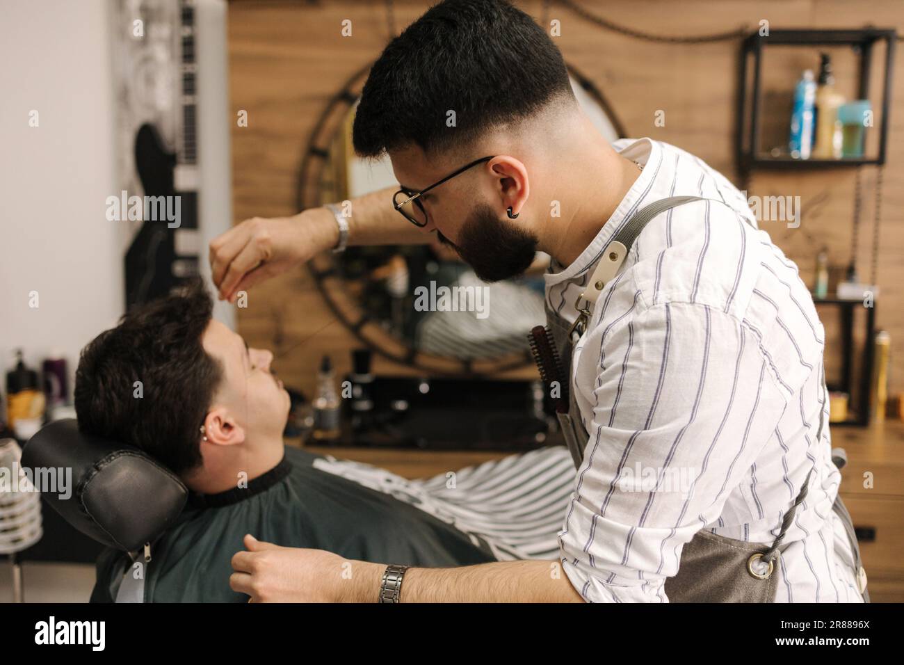 Process of threading procedure in barber shop. Professional barber