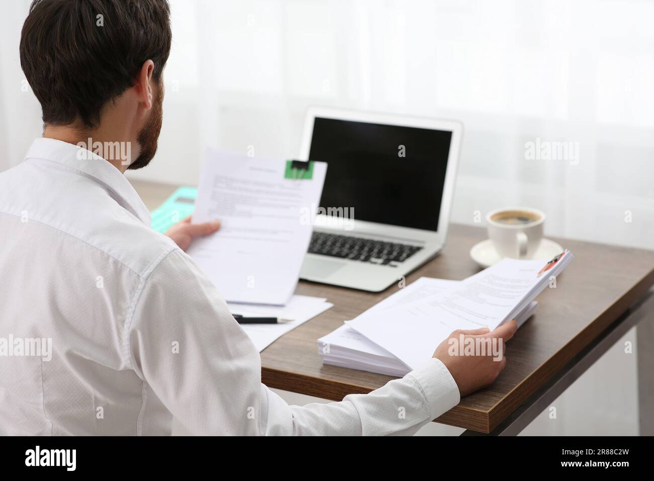 Businessman working with documents at table in office, back view Stock Photo