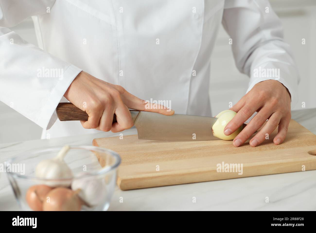 https://c8.alamy.com/comp/2R88F28/professional-chef-cutting-onion-at-white-marble-table-indoors-closeup-2R88F28.jpg