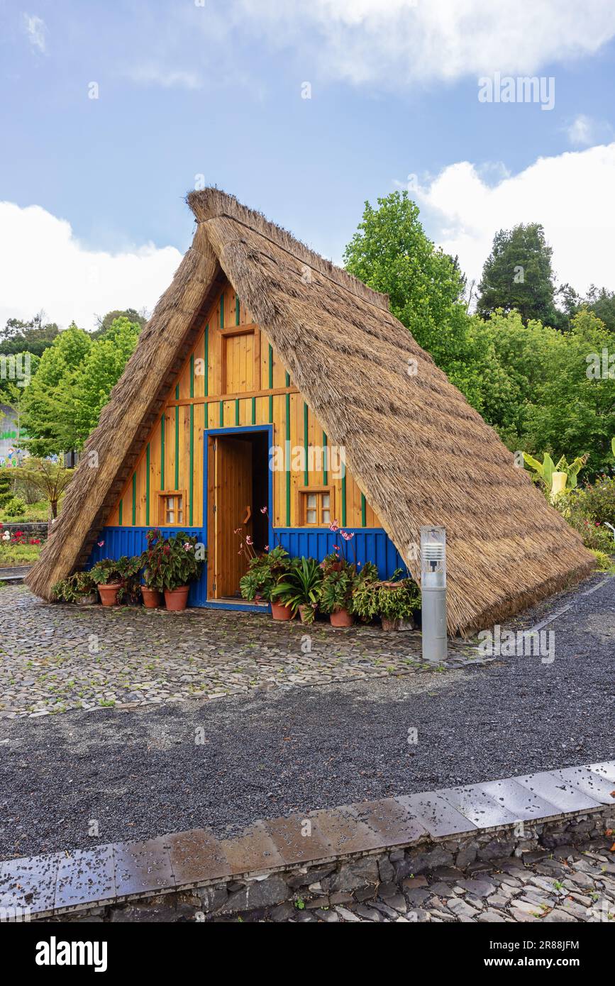 Blue and yellow Santana style house with high thatch roofs Stock Photo