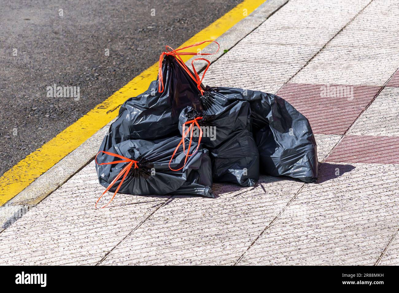 https://c8.alamy.com/comp/2R88MKH/discarded-full-plastic-garbage-bags-on-an-empty-city-street-close-up-environment-pollution-concept-2R88MKH.jpg