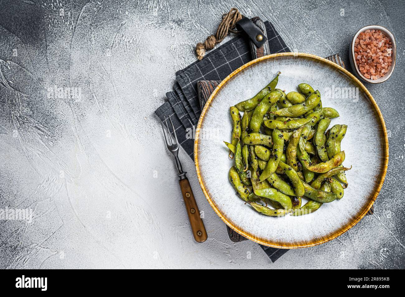 Spicy grilled Edamame Soy Beans with sea salt in a plate. White