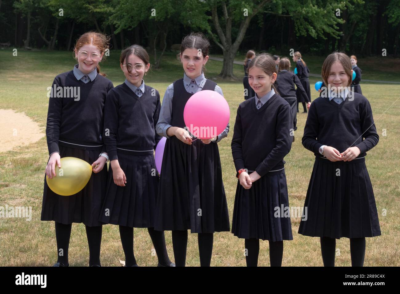 Portrait of 5 modestly dressed orthodox Jewish students in a park celebrating the end of their school semester. In Monsey, NY, June 2023 Stock Photo