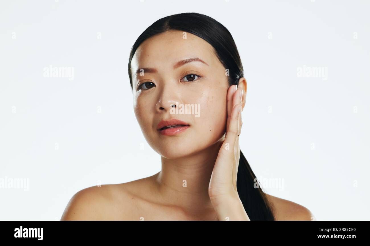 Skincare, asian woman and touch face in studio for beauty, dermatology