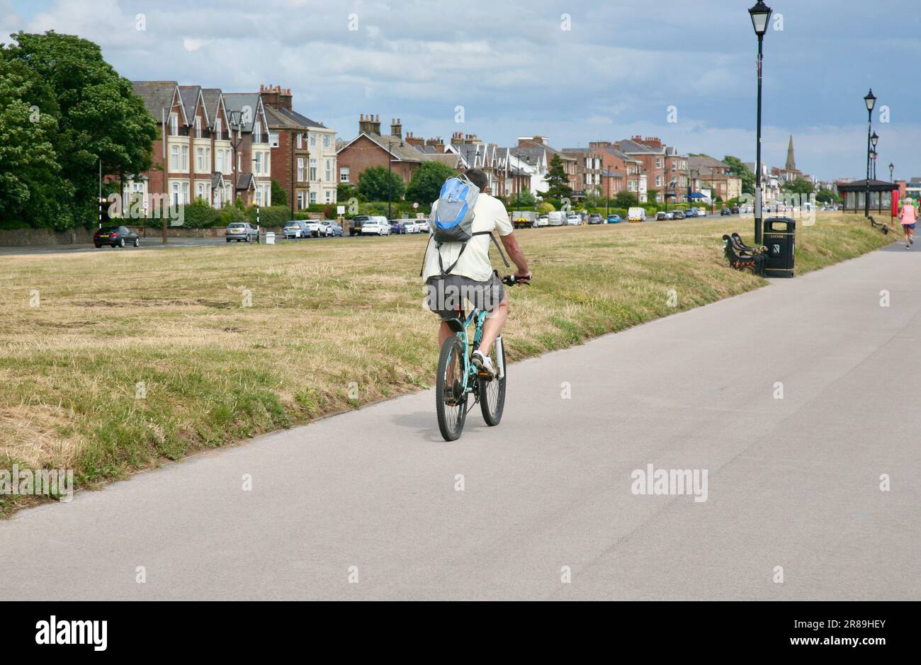 A lone cyclist on the promenade, Lytham St Annes, Lancashire, United Kingdom, Europe Stock Photo