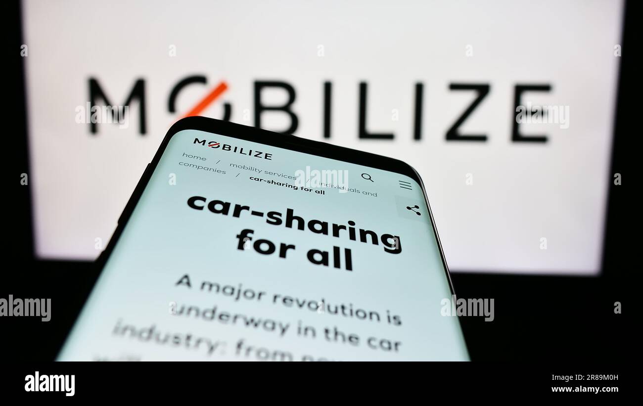 Smartphone with website of automotive mobility company Mobilize on screen in front of business logo. Focus on top-left of phone display. Stock Photo