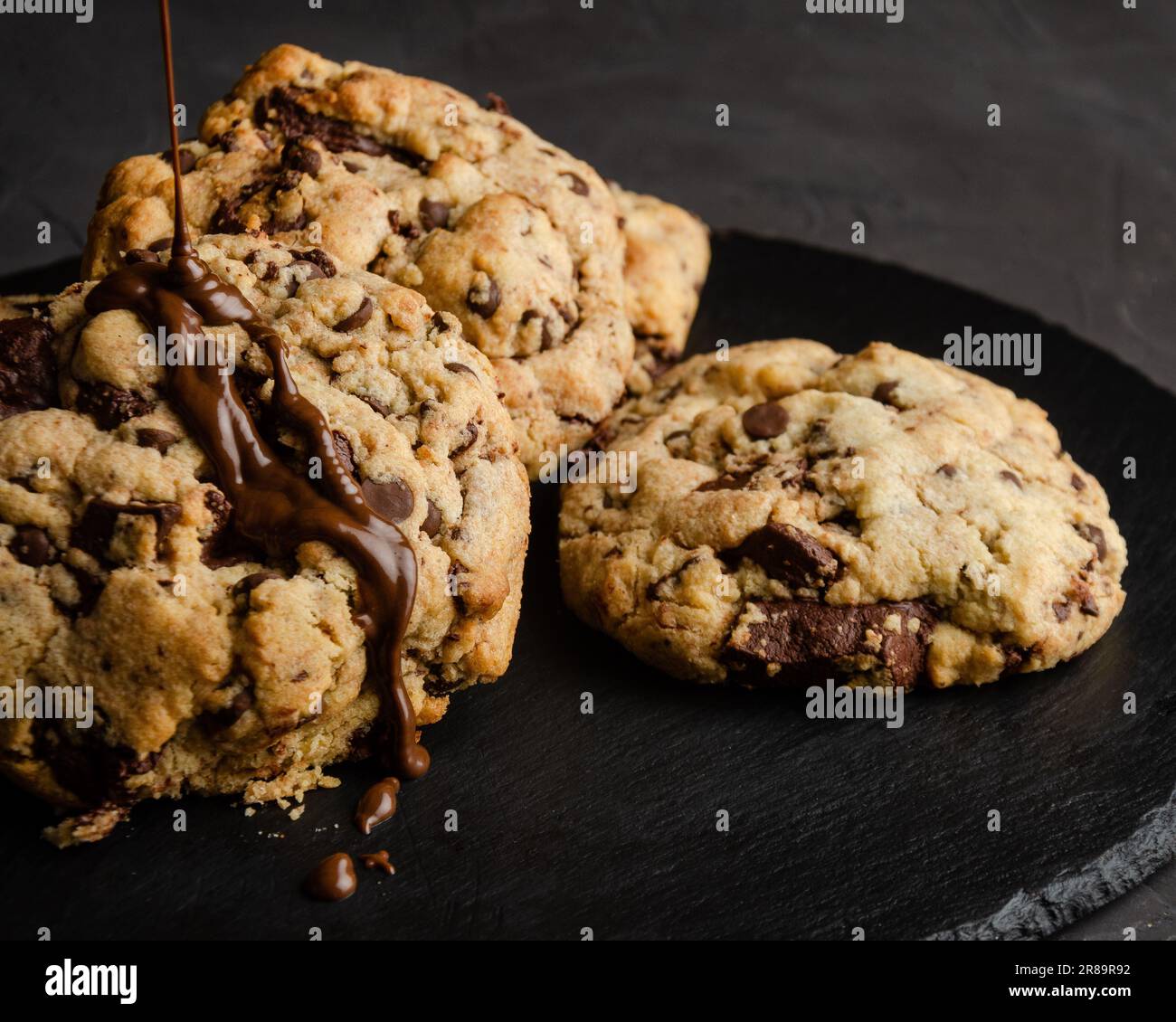 Chocolate chip cookies with chocolate syrup, on black background Stock