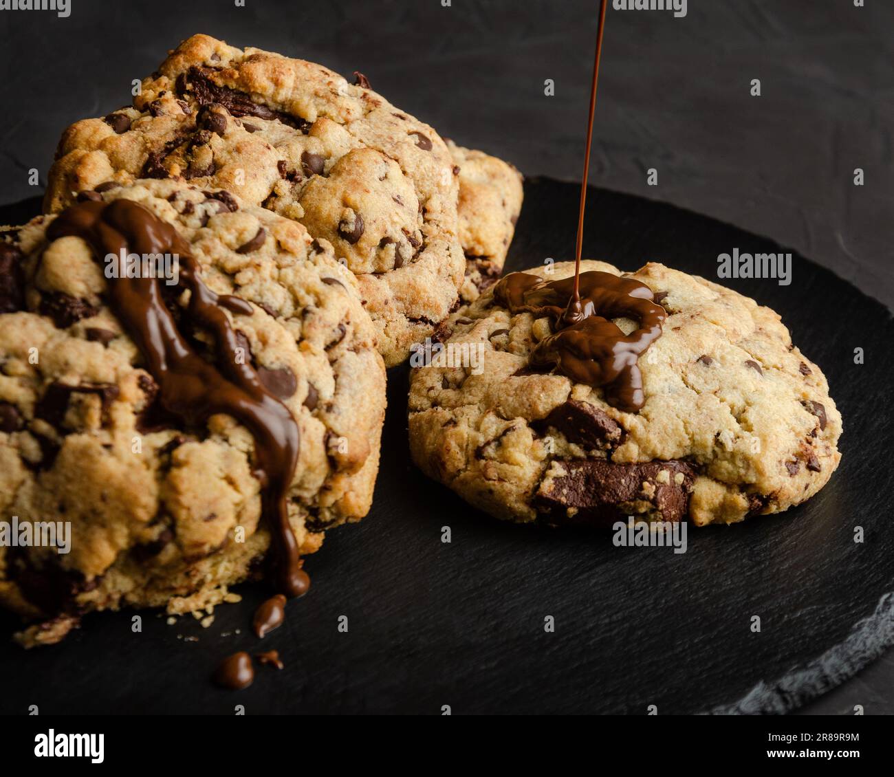 Chocolate chip cookies with chocolate syrup, on black background Stock Photo