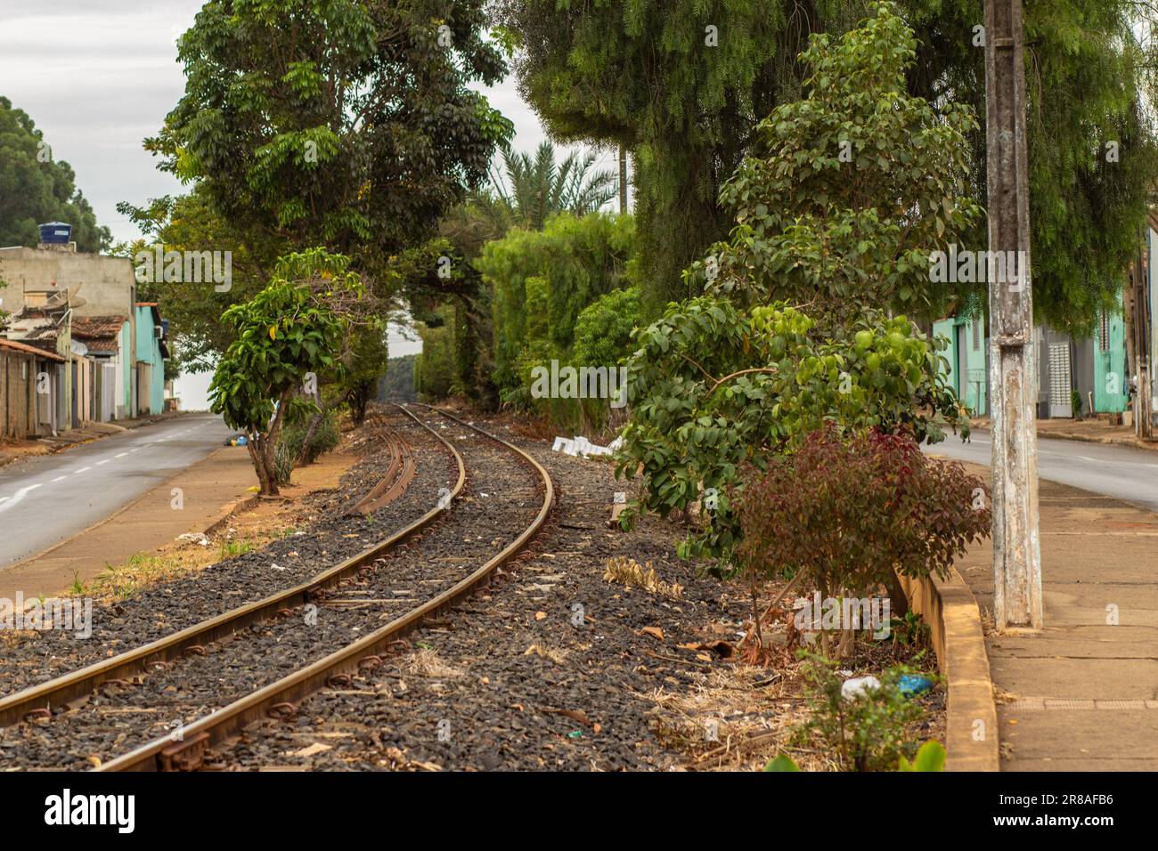 Catalao, Goias, Brazil – June 16, 2023:  A stretch of locomotive tracks passing between trees within the town of Catalao in Goias. Stock Photo