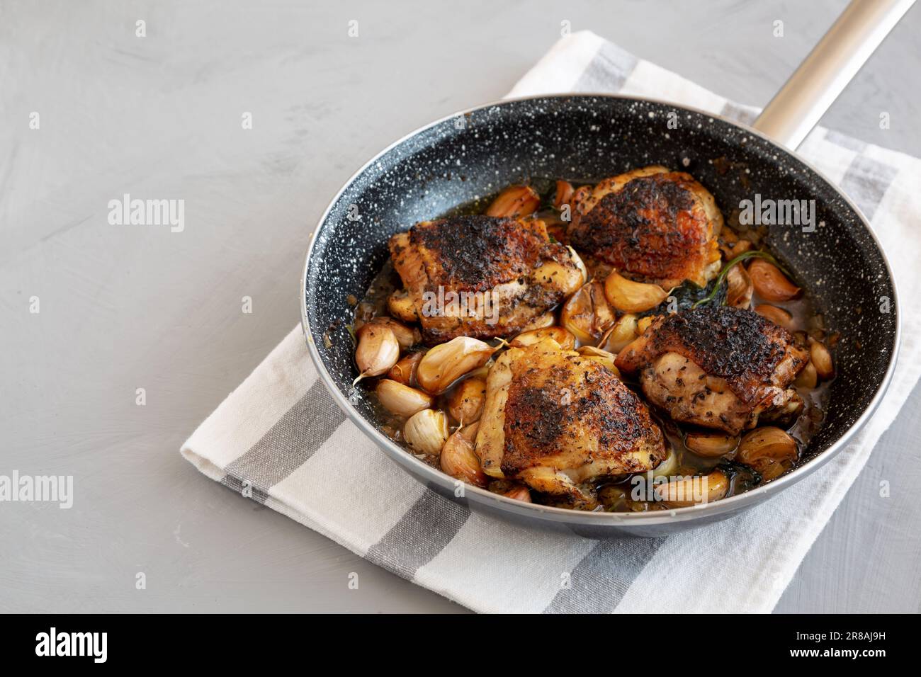 Homemade Chicken With 40 Cloves of Garlic on a Plate, side view. Copy space. Stock Photo