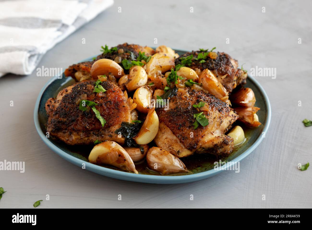 Homemade Chicken With 40 Cloves of Garlic on a Plate, side view Stock