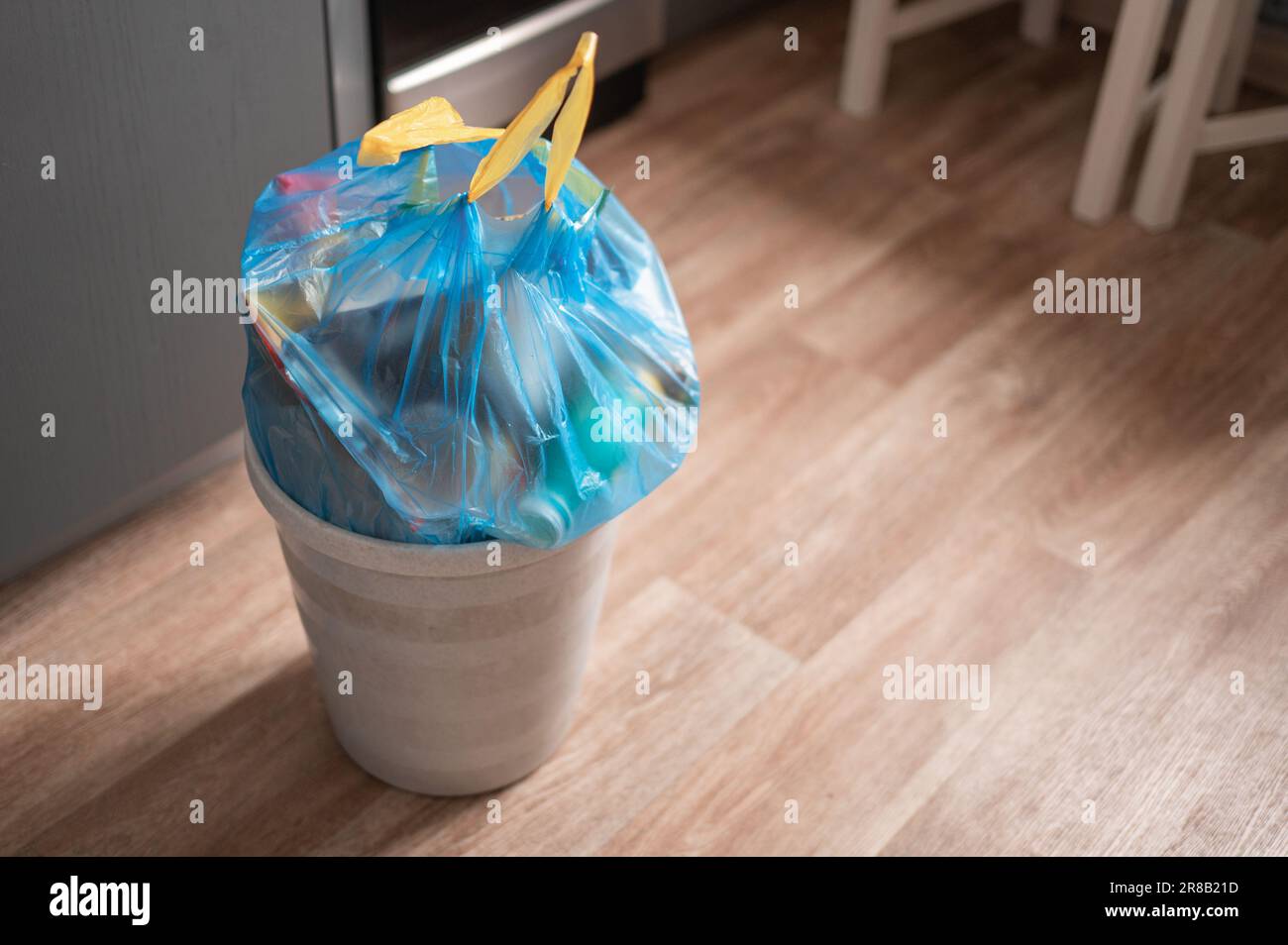 Full garbage trash in a trash bag with strings can standing at room Stock Photo Alamy
