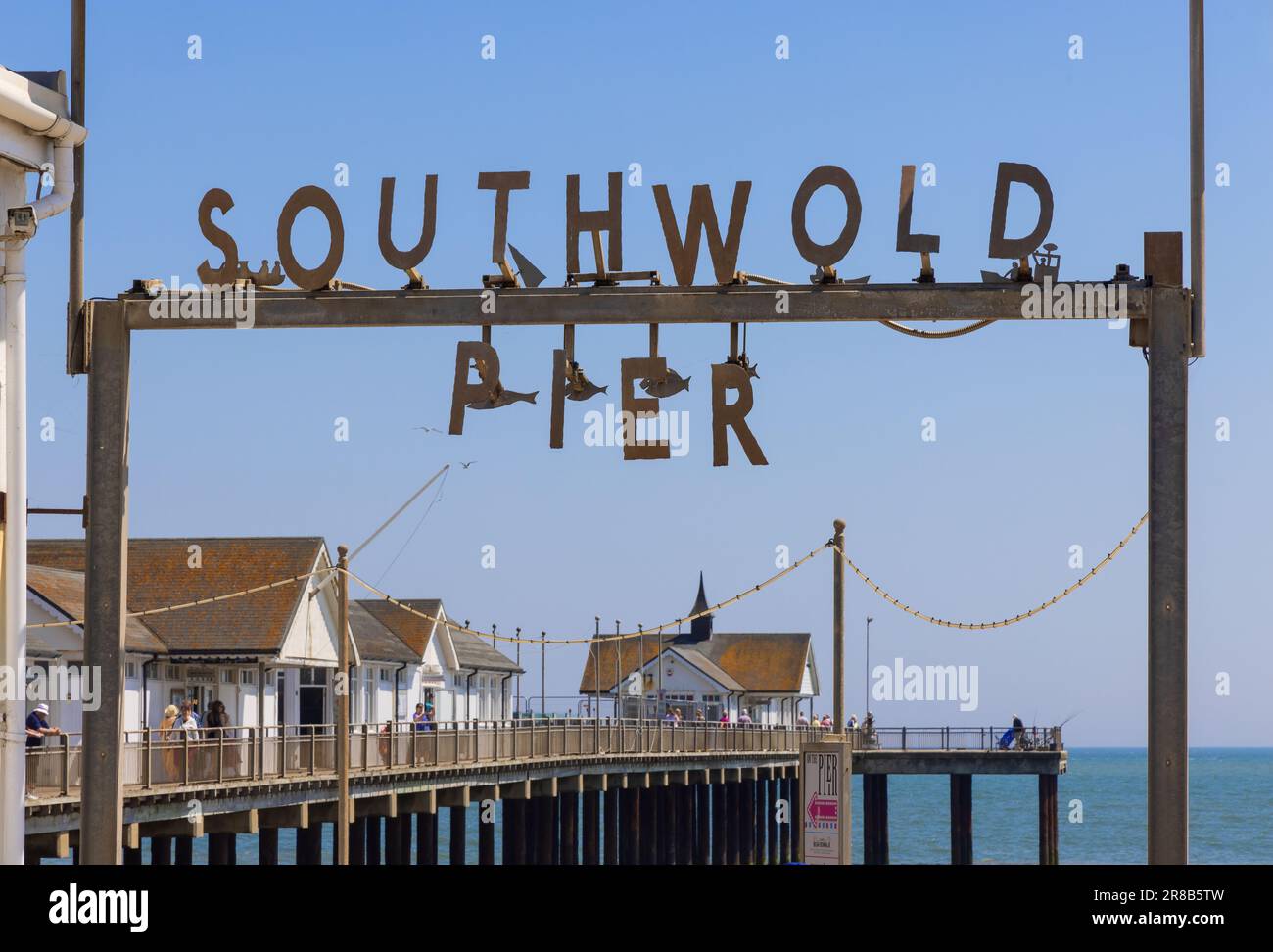 Sign over the entrance of Southwold Pier, with the pier in the background.. Suffolk. UK Stock Photo