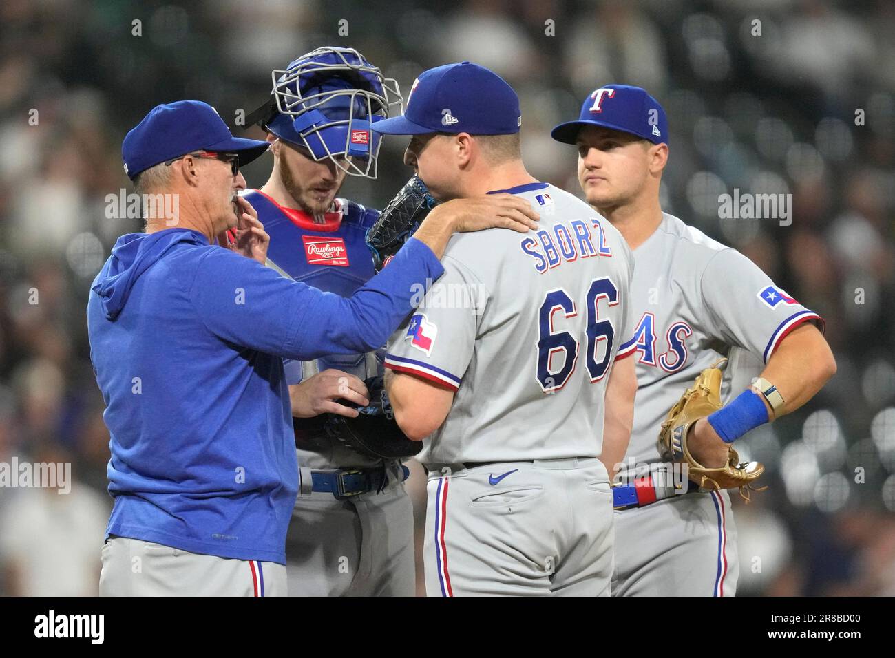 Texas Rangers pitching coach Mike Maddux talks to relief pitcher Josh Sborz as catcher Jonah Heim and third baseman Josh Jung listen during a baseball game against the Chicago White Sox Monday,