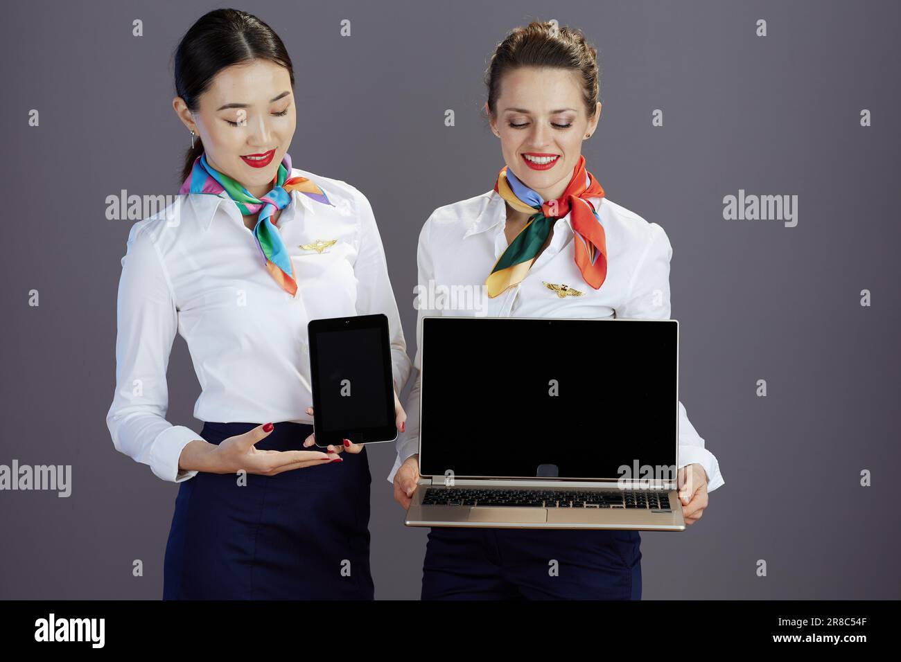 happy elegant female flight attendants in blue skirt, white shirt and ...