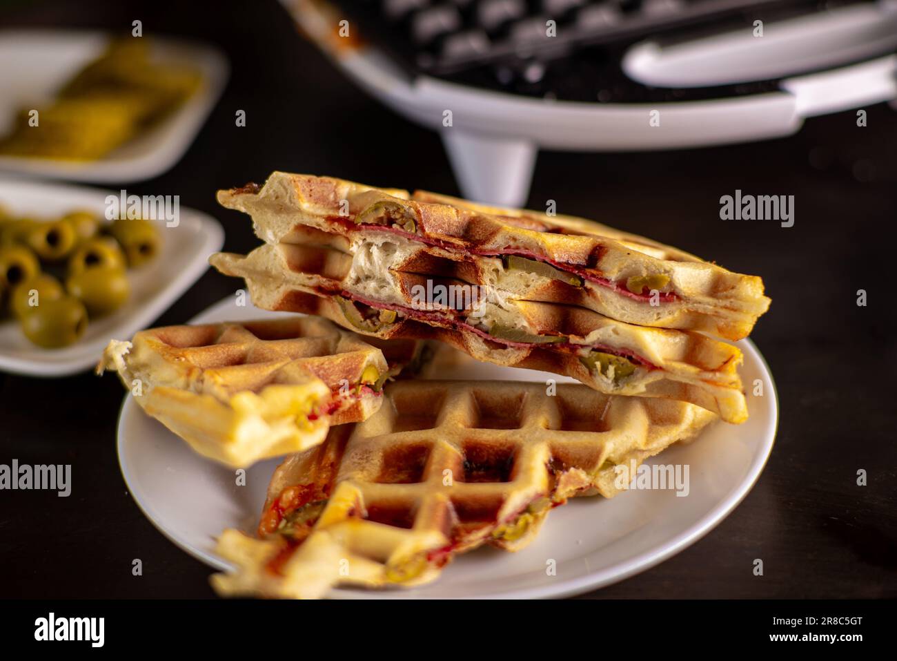 https://c8.alamy.com/comp/2R8C5GT/pizza-waffles-piffle-waffles-stuffed-with-sausage-cheese-tomatoes-on-a-plate-2R8C5GT.jpg