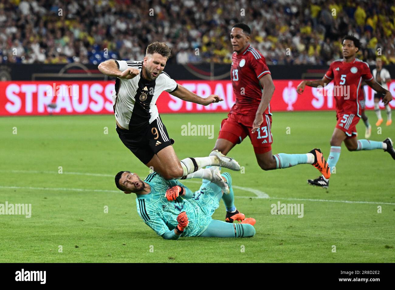 Gelsenkirchen, Germany. 20th June, 2023. Soccer: Internationals, Germany - Colombia, Veltins Arena. Germany's Niclas Füllkrug (center) falls over Colombia goalkeeper Camilo Vargas (bottom). IMPORTANT NOTE: In accordance with the regulations of the DFL Deutsche Fußball Liga and the DFB Deutscher Fußball-Bund, it is prohibited to use or have used photographs taken in the stadium and/or of the match in the form of sequence pictures and/or video-like photo series. Credit: Federico Gambarini/dpa/Alamy Live News Stock Photo