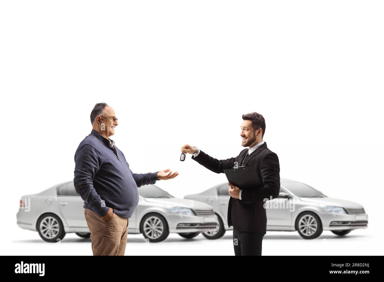 Car salesman giving keys to a mature man isolated on white background Stock Photo