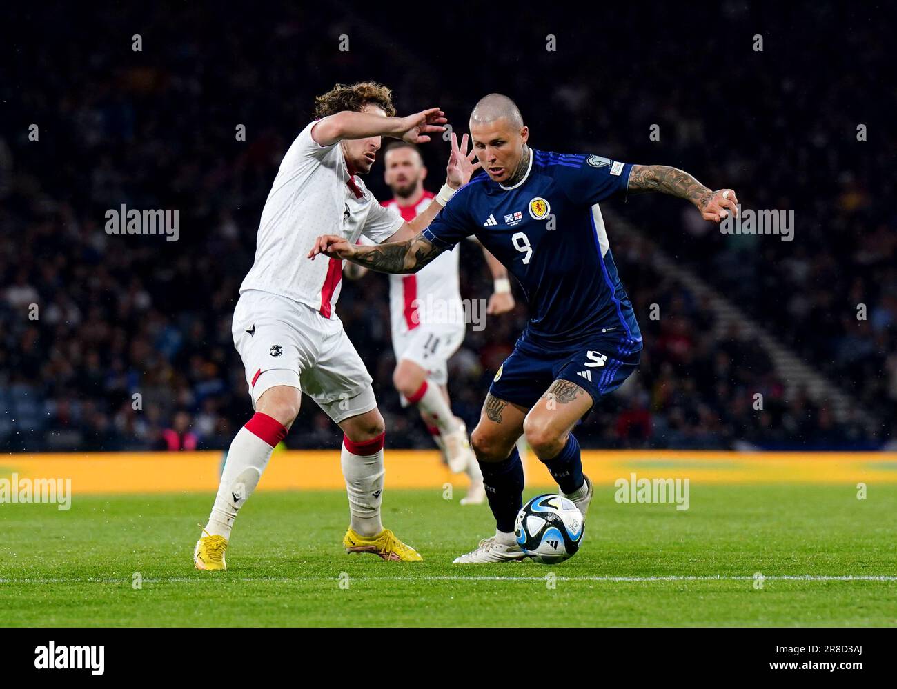 Scotland's Lyndon Dykes (right) and Georgia's Luka Gagnidze battle for the ball during the UEFA Euro 2024 Qualifying Group A match at Hampden Park, Glasgow. Picture date: Tuesday June 20, 2023. Stock Photo