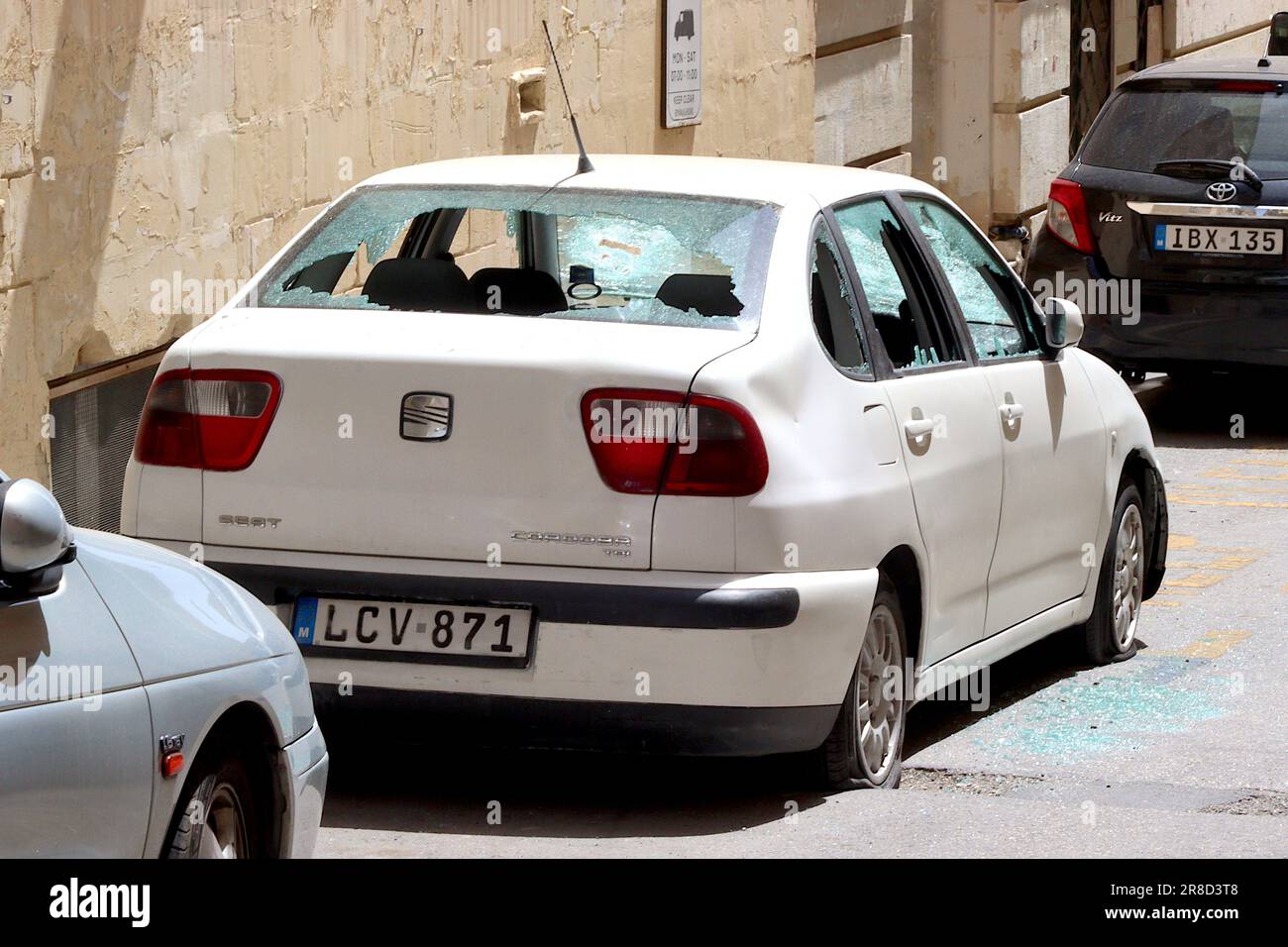 SEAT Cordoba vandalised with all windows smashed, broken headlight glass, tyres deflated and bodywork hammer attacked, Valletta, Malta. Stock Photo