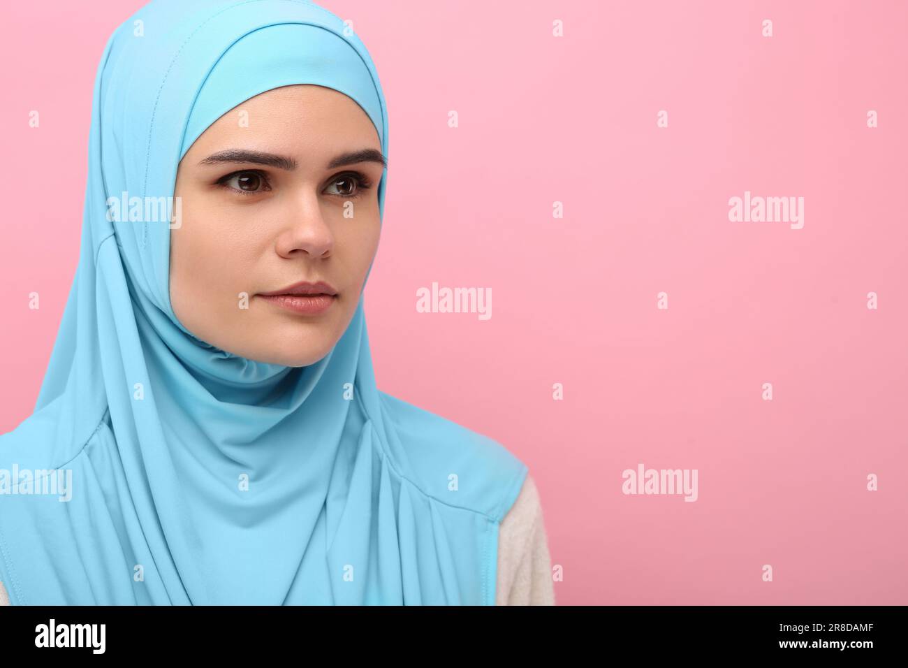 Portrait of Muslim woman in hijab on pink background, space for text ...
