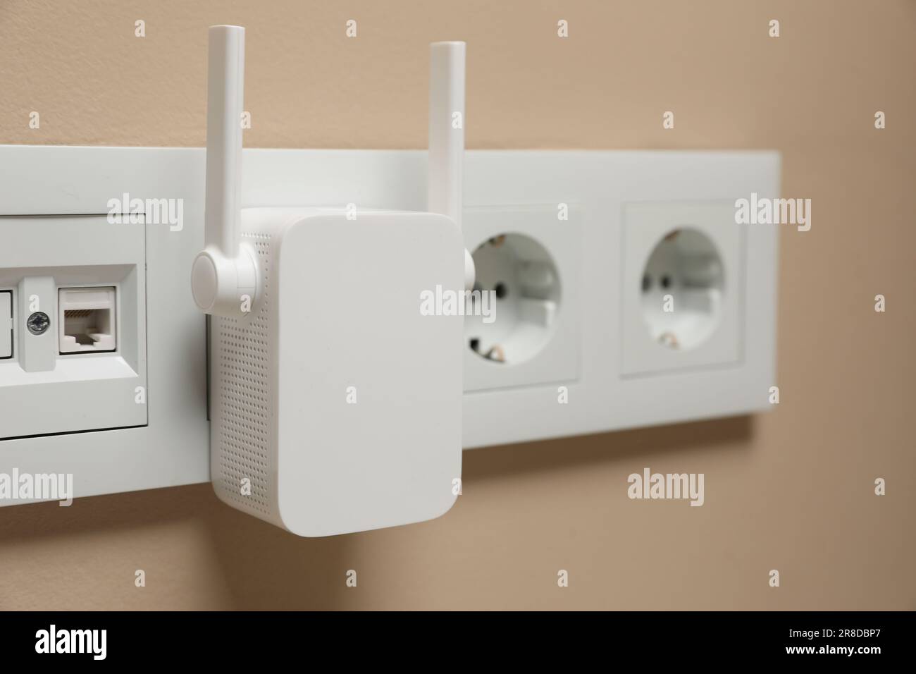 Wireless Wi-Fi repeater in power socket on beige wall, closeup Stock ...