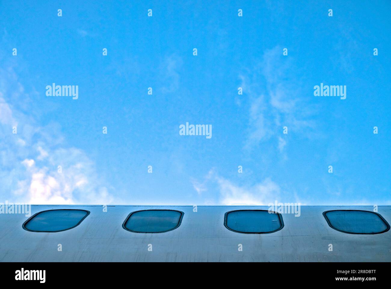 windows of a plane part of fuselage and sky Stock Photo