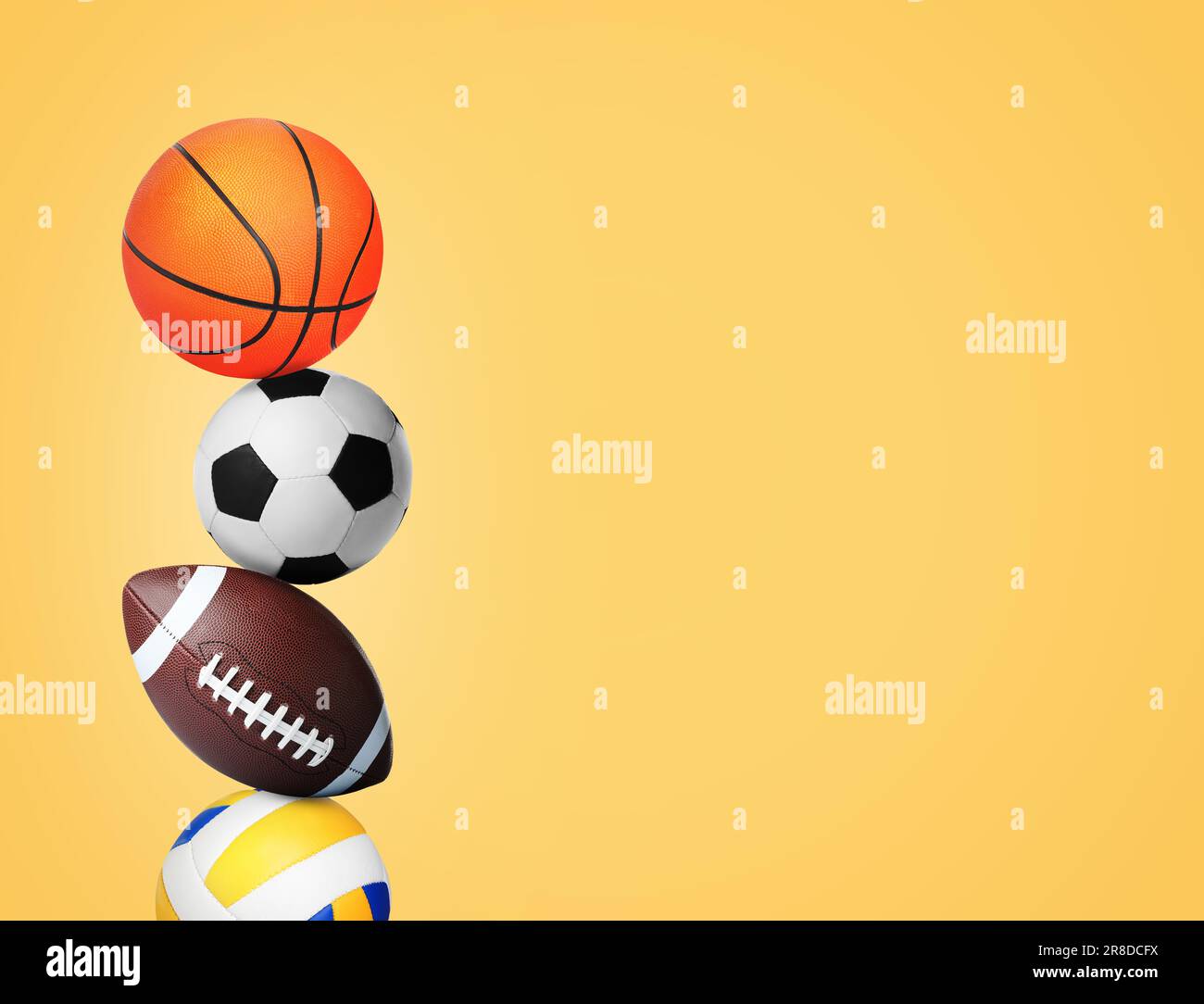 Stack of different sport balls on gold background, space for text Stock Photo