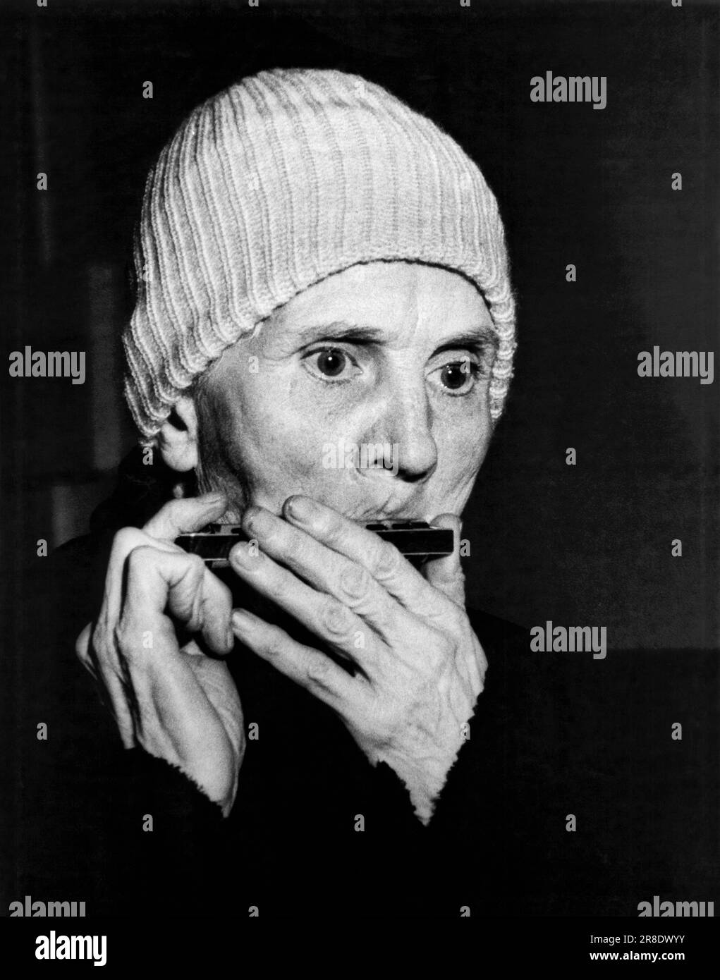 New York, New York 1932. A man who plays his harmonica on the streets