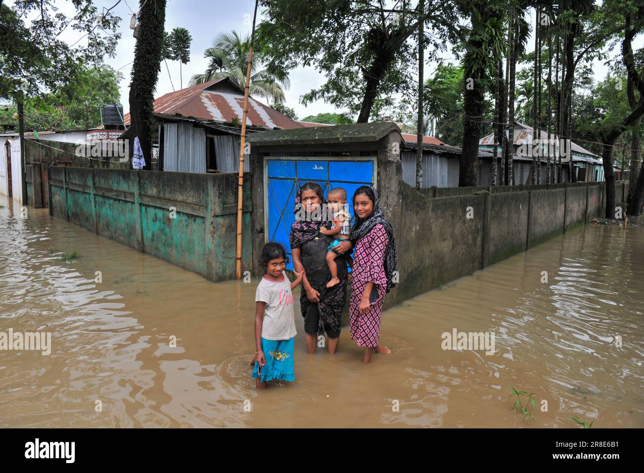 People wade through a submerged road of Sylhet town. Incessant rains ...