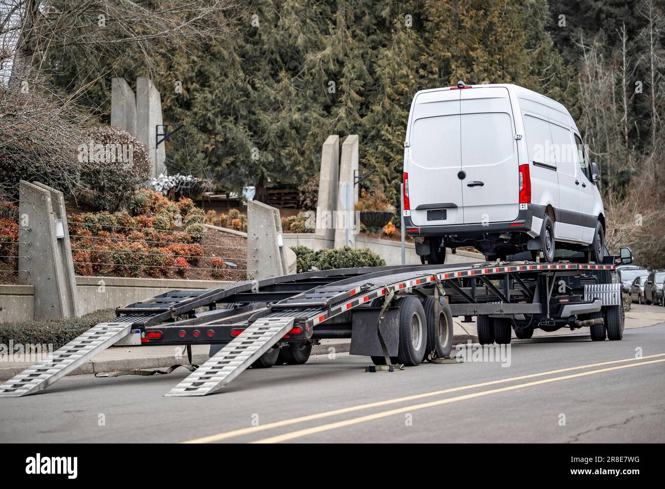 Industrial standard low cab profile long haul white car hauler rig truck  delivered cargo mini van on hydraulic semi trailer unloading this van on  the Stock Photo - Alamy