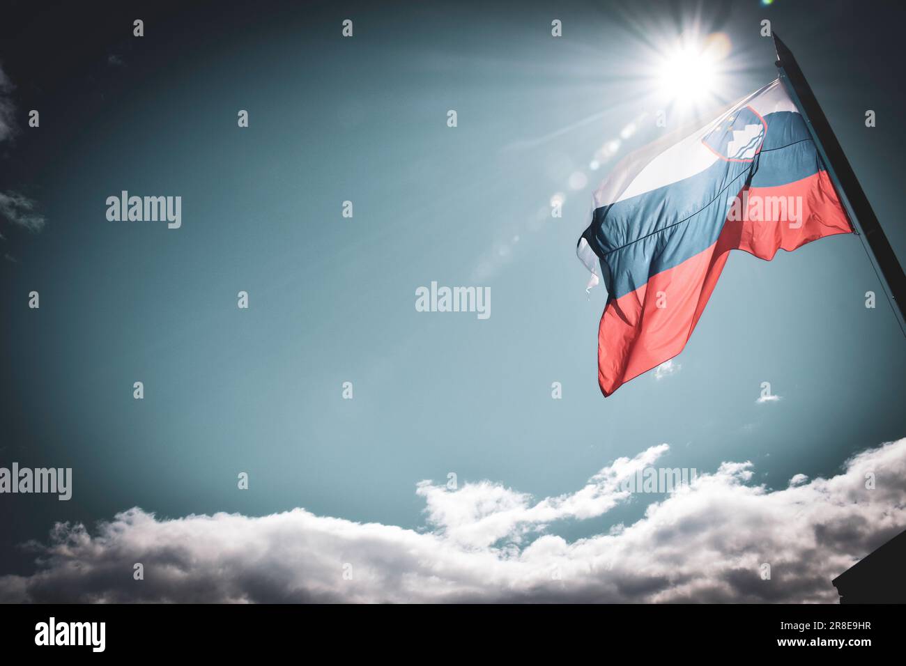 Fluttering Slovene Flag against the Sun - Bled, Slovenia Stock Photo