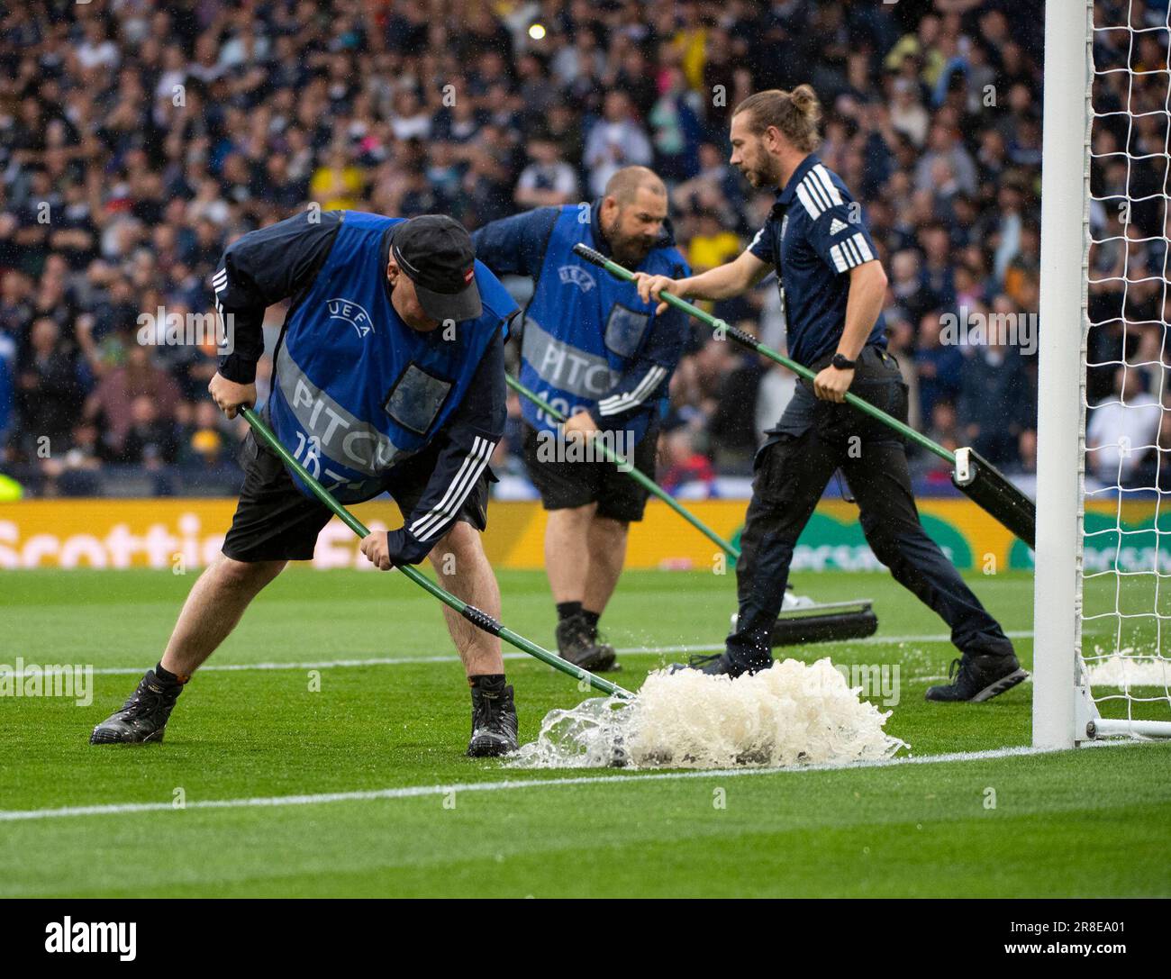 GLASGOW, SCOTLAND - JUNE 20: Groundsmen work to dry the pitch during the UEFA EURO 2024 qualifying round group A match between Scotland and Georgia at Hampden Park on June 20, 2023 in Glasgow, Scotland. (Photo by Ian Jacobs/MB Media/) Stock Photo