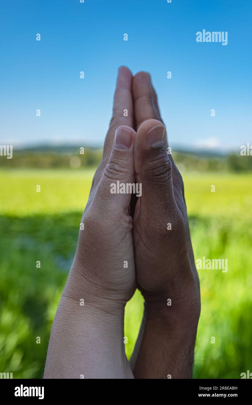 Black male and white female hands touching palms each other. Interracial couple holding hands outdoors. White caucasian and black afro american hands Stock Photo