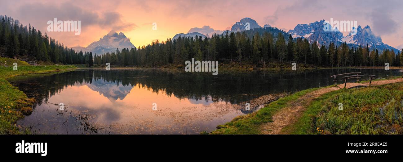 A wide 3:1 panoramic sunrise at Lake Antorno (Lago d'Antorno), a small mountain lake in the Italian Dolomites. It is located in the north of the Bellu Stock Photo