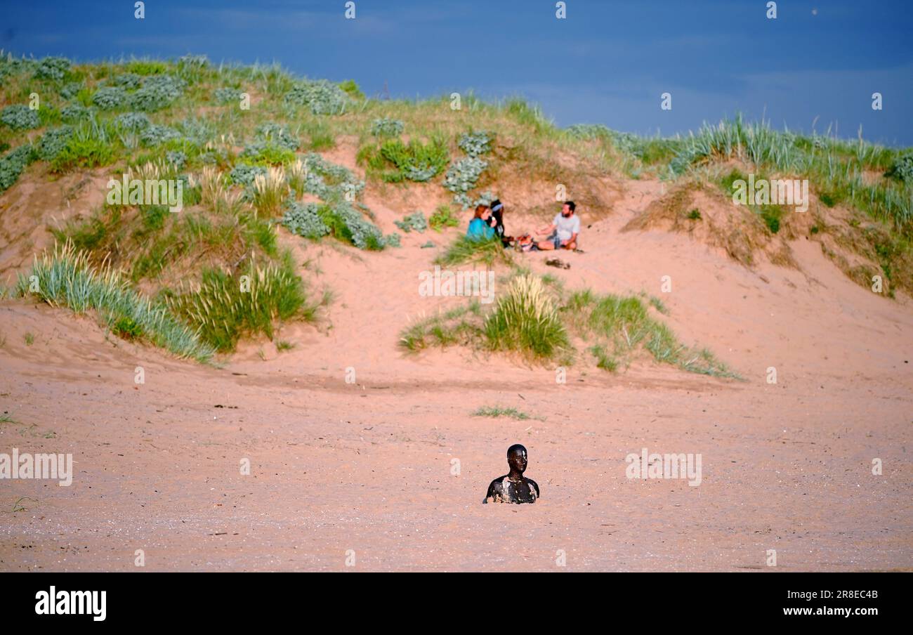 People enjoying the warm weather at Another Place, Anthony Gormley's Ironmen statues on Crosby Beach, Merseyside, on the eve of the Summer Solstice. Picture date: Tuesday June 20, 2023. Stock Photo