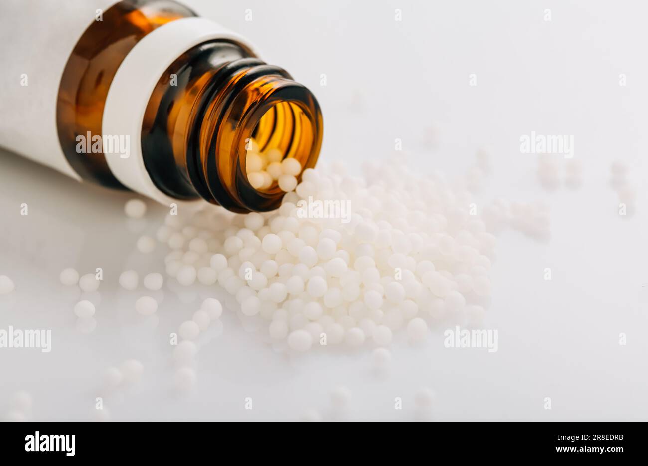 Homeopathic globules and glass bottle. Homeopathy, alternative medicine. Stock Photo