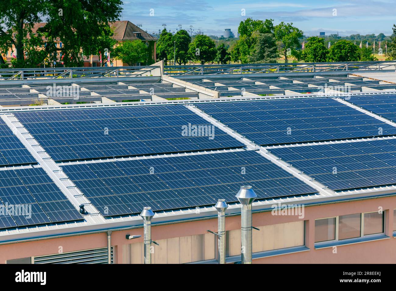Solar panels installed on a roof of a large industrial building or a warehouse. Stock Photo